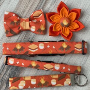 A bow tie, key chain and flower on top of a table.