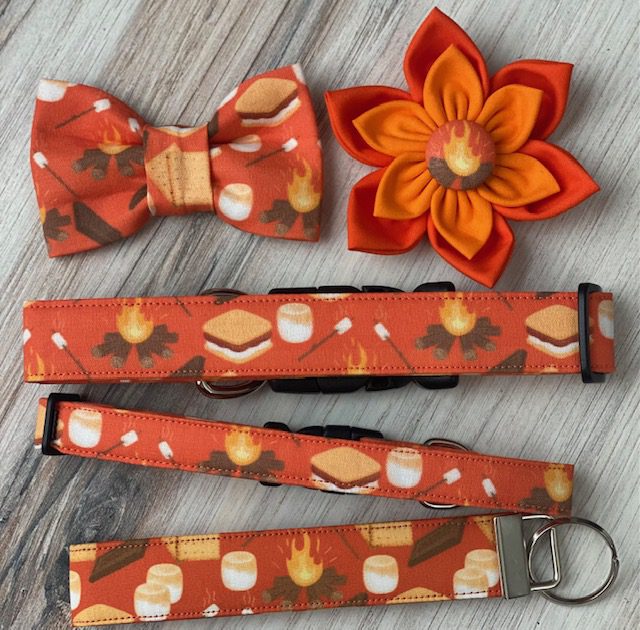 A bow tie, key chain and flower on top of a table.