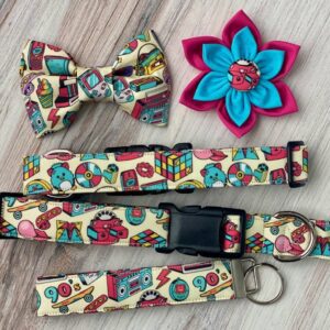 A dog collar, bow tie and flower are all on the table.