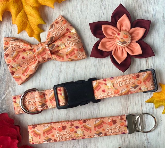 A dog collar, bow tie and flower are all on the table.