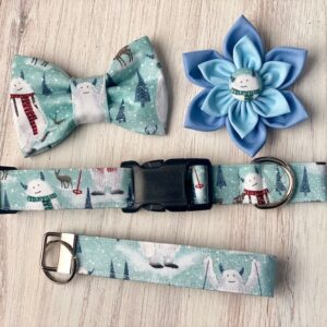 A dog collar, bow tie and flower on top of a table.