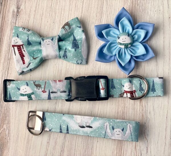 A dog collar, bow tie and flower on top of a table.