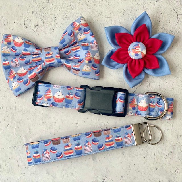 A dog collar, bow tie and flower are laying on the ground.